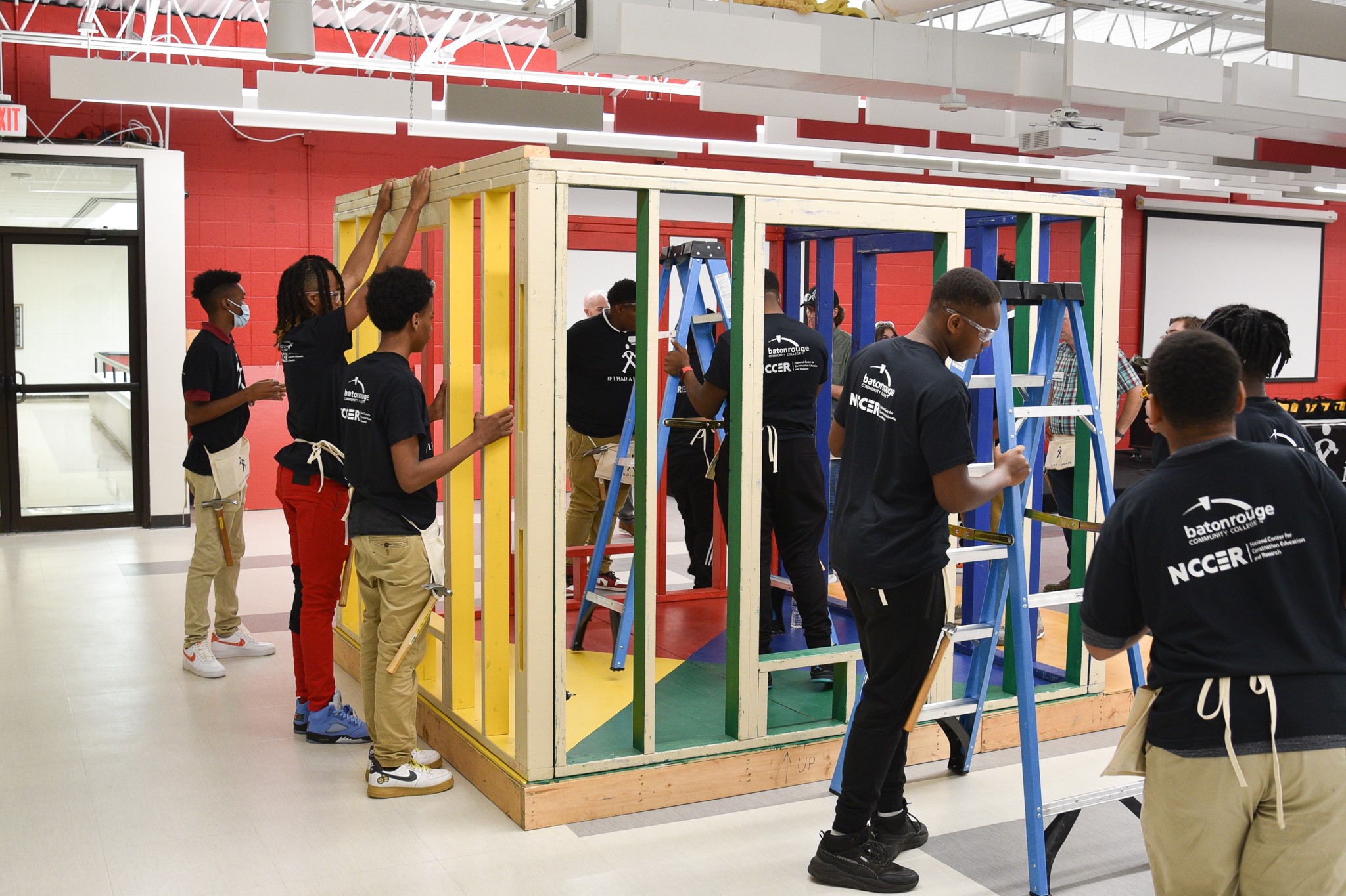 Participating Istrouma High School students work with master carpenter Perry Wilson on the Hammer House Build Experience at Baton Rouge Community College.